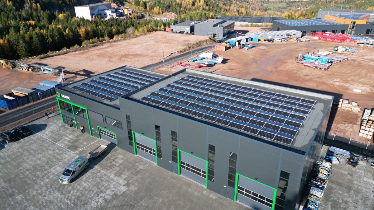 Hallgruppens Industribygning med solcellepaneler på taget, set fra luften.