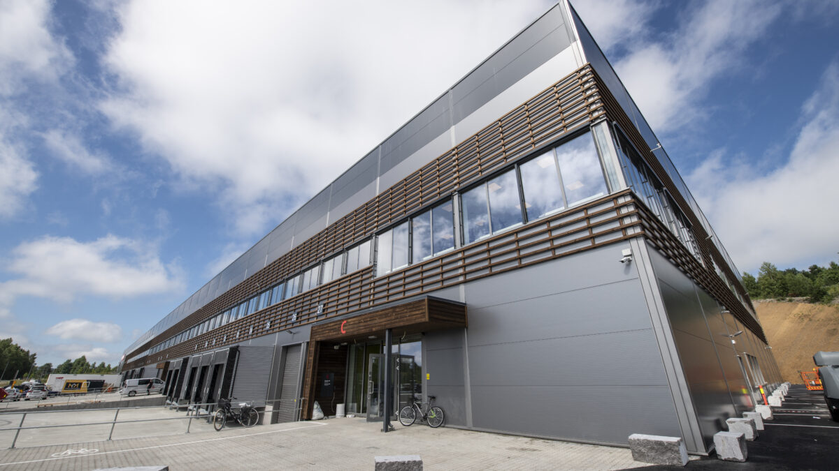 Industribygning levert av Hallgruppen med træpaneldetaljer og store vinduer.