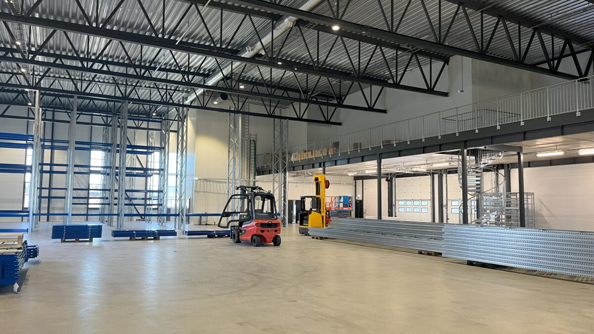 Industribygning og Lagerhal indendørs med stålreoler, traverskran og truck levert av Hallgruppen.