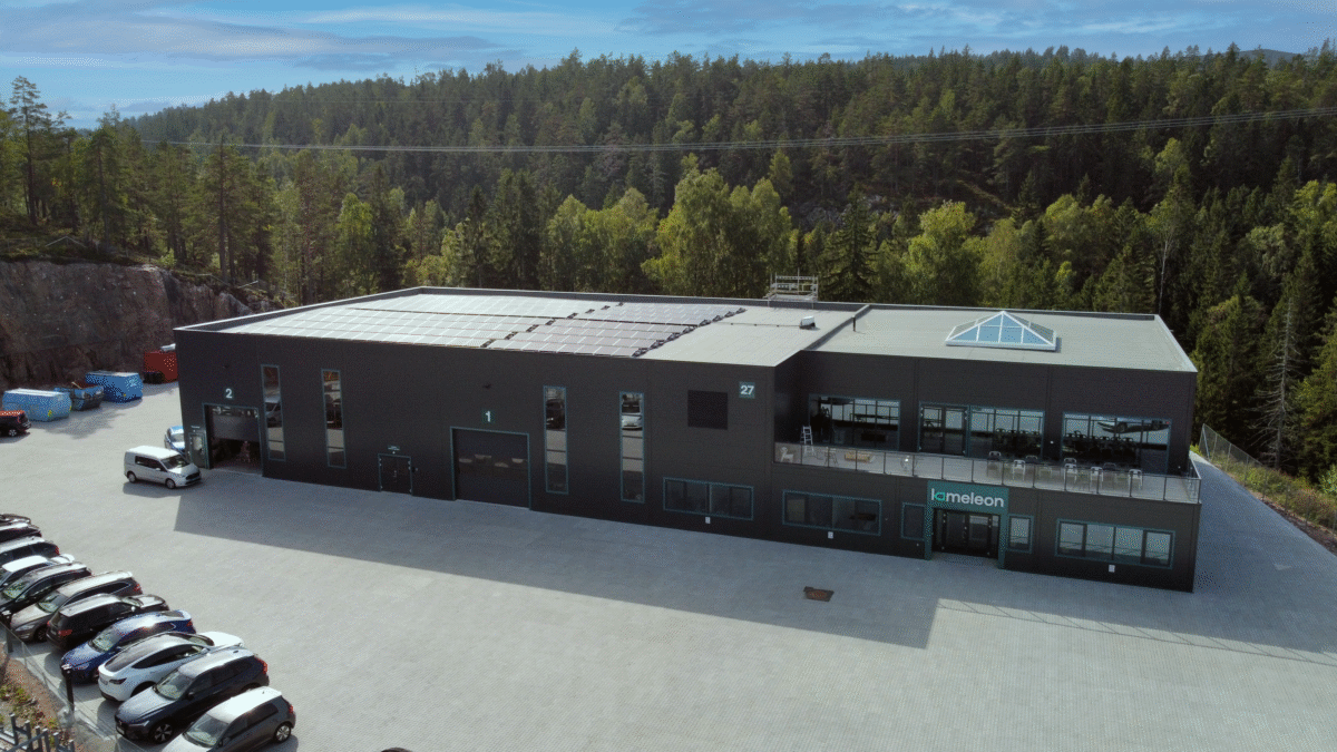 Hallgruppens Industribygning, Mørk facadehal med solcellepaneler og kontordel.